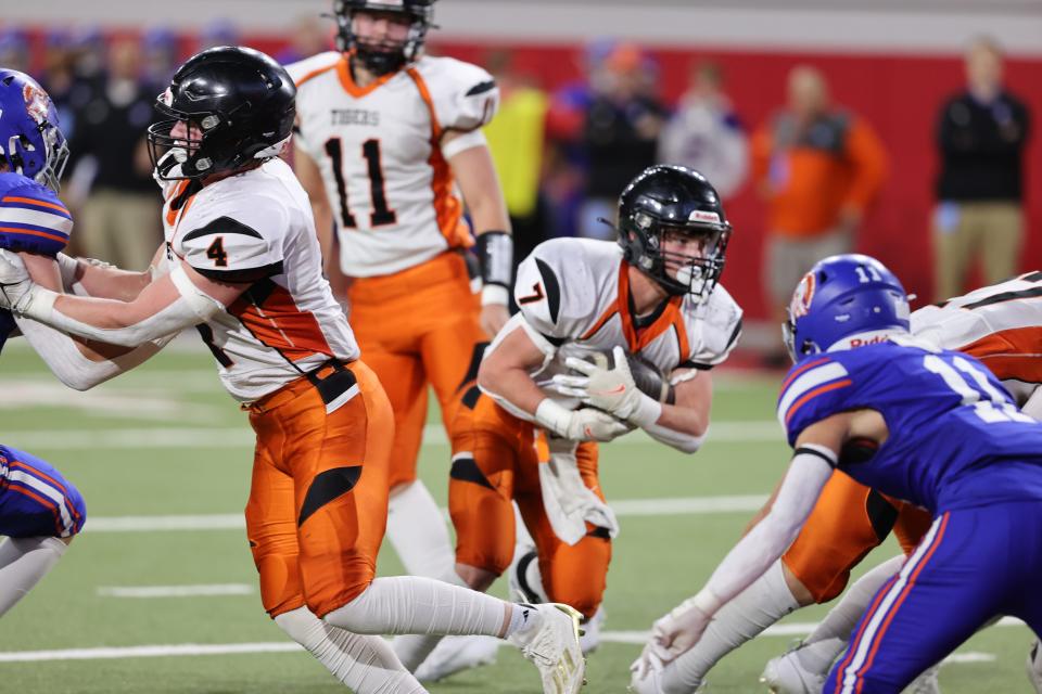 Howard''s Taiden Hoyer (11) follows a block from teammate Connor Prunty (4) to pick up some yardage as Parkston's Luke Bormann pursues during the state Class 9AA football championship on Thursday, Nov. 9, 2023 in Vermillion's DakotaDome. Parkston won 12-7.