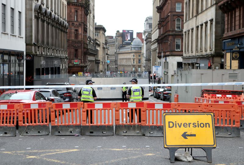 Police officers stand near the scene of reported multiple stabbings at West George Street in Glasgow