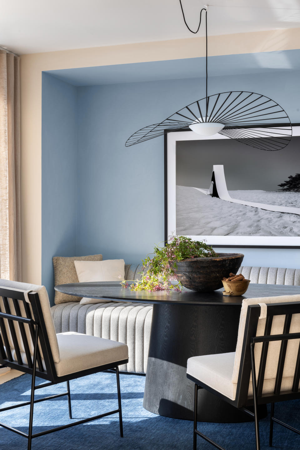 A dining room with light blue and beige walls