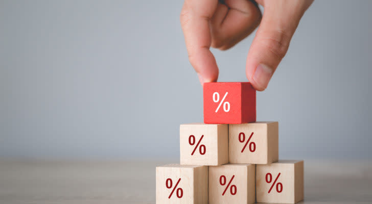 Percentage symbols on wooden cubes stacked in a triangle. The top cube is red.