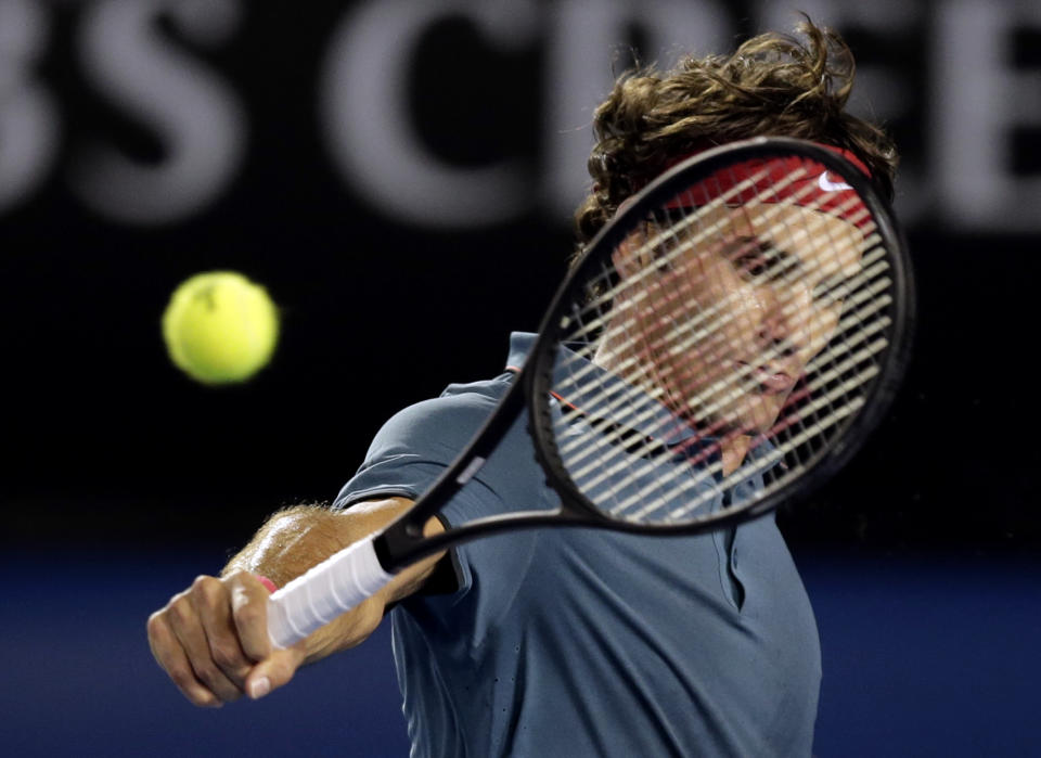 Roger Federer of Switzerland makes a backhand return to Rafael Nadal of Spain during their semifinal at the Australian Open tennis championship in Melbourne, Australia, Friday, Jan. 24, 2014.(AP Photo/Rick Rycroft)