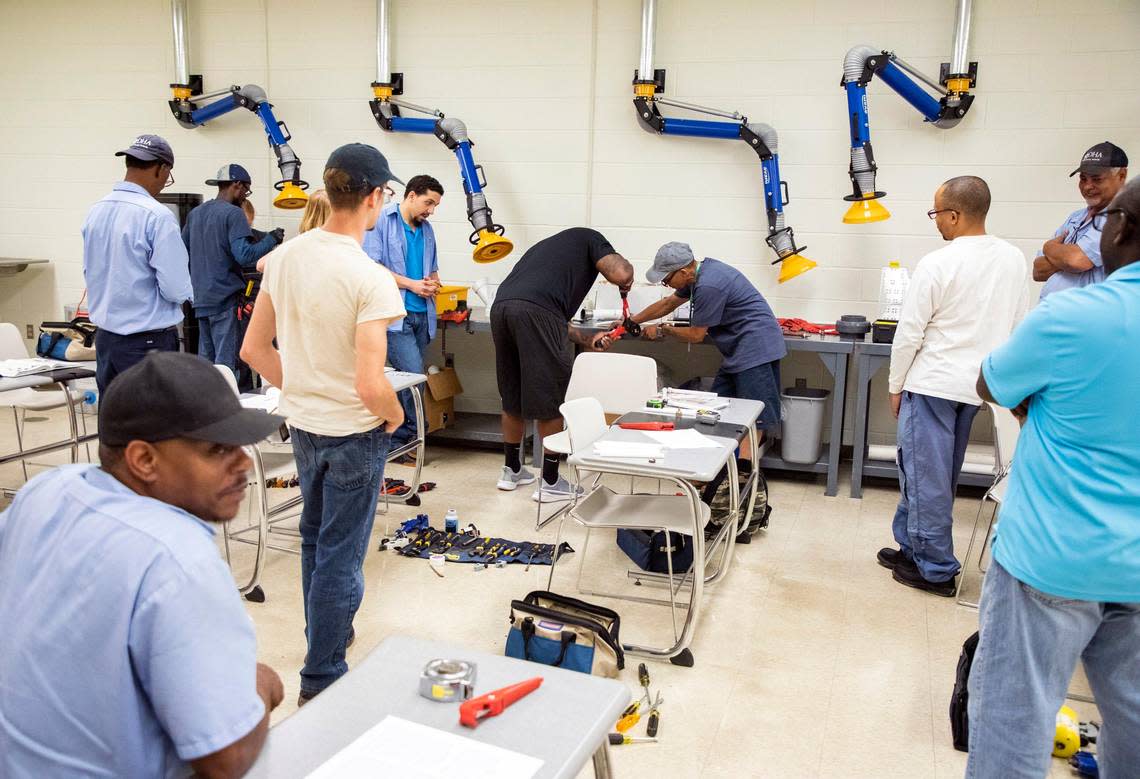 Voters will consider a $112.7 million bond for Durham Tech. In this file photo, fellow students watch as Kwame Yearwood, center left, helps instructor Robert Brewer cut a pipe during a plumbing class at Durham Technical Community College on Thursday, Aug. 30, 2019, in Durham, N.C.