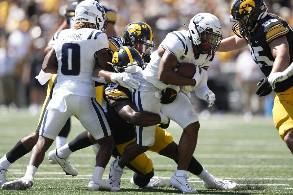 Utah State wide receiver Micah Davis (4) is tackled by Iowa linebacker Jay Higgins (34) during the first half of an NCAA college football game, Saturday, Sept. 2, 2023, in Iowa City, Iowa. (AP Photo/Charlie Neibergall) | AP