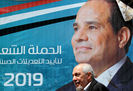 A man walks in front of a banner depicting Egyptian President Abdel Fattah al-Sisi before the upcoming referendum on constitutional amendments in Cairo, Egypt April 16, 2019. REUTERS/Mohamed Abd El Ghany/Files