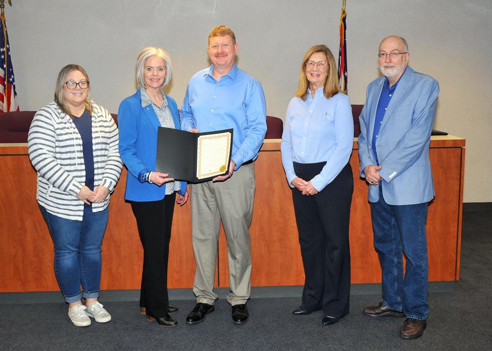 Wayne County Children Services Executive Assistant Ashley Poynter (left) and Executive Director Deanna Nichols-Stika accept a proclamation from Wayne County Commissioners Jonathan Hofstetter, Sue Smail, and Ron Amstutz.