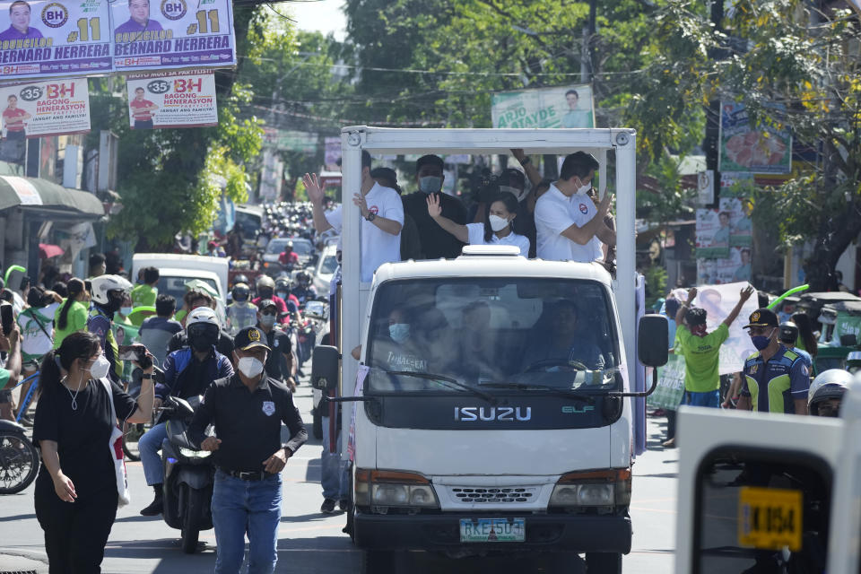 Quezon City Mayor Joy Belmonte, center, waves during a motorcade as she starts her re-election campaign in Quezon City, Philippines on Friday, March 25, 2022. Candidates for thousands of provincial, town and congressional posts started campaigning across the Philippines Friday under tight police watch due to a history of violent rivalries and to enforce a lingering pandemic ban on handshakes, hugging and tightly packed crowds that are a hallmark of often circus-like campaigns. (AP Photo/Aaron Favila)