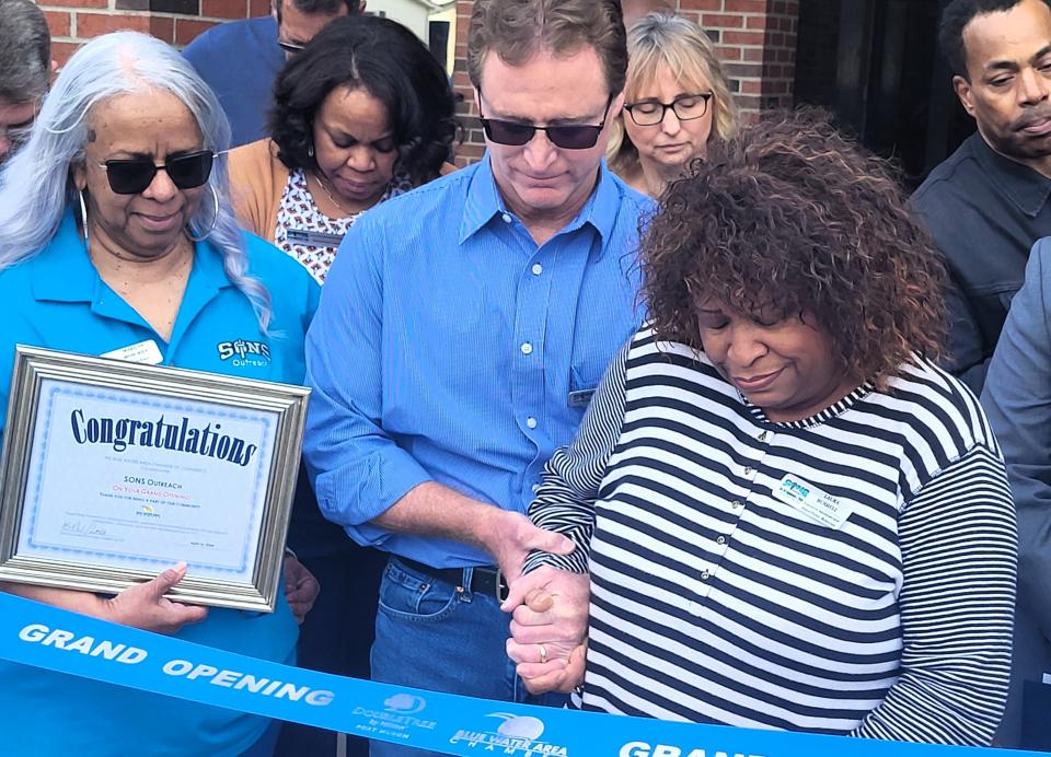 Jeff Kaczperski, board chairman for SONS Outreach, hangs on to Laura Burrell, a founding administrator for the nonprofit on Tuesday, April 16, 2024, outside the group's new resource center.