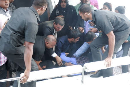 Officials carry an injured woman off the speed boat of Maldives President Abdulla Yameen (not pictured) after an explosion onboard, in Male, Maldives September 28, 2015. REUTERS/Waheed Mohamed
