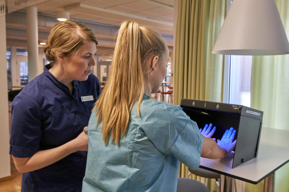 Former Scandinavian Airlines flight attendant, Mathilda Malm tests her hands for bacteria as she learns basic skills on to assist in nursing homes and hospitals due to the coronavirus outbreak, in Stockholm, Wednesday, April 1, 2020. The airline announced in mid-March the temporary layoff of up to 10,000 employees, 90% of its workforce amid a drop in demand for international travel as governments clamped down on public events to contain the virus outbreak. With the help of a foundation, it is one of several airlines offering former staff the chance to work on the front line of the pandemic. (AP Photo/David Keyton)