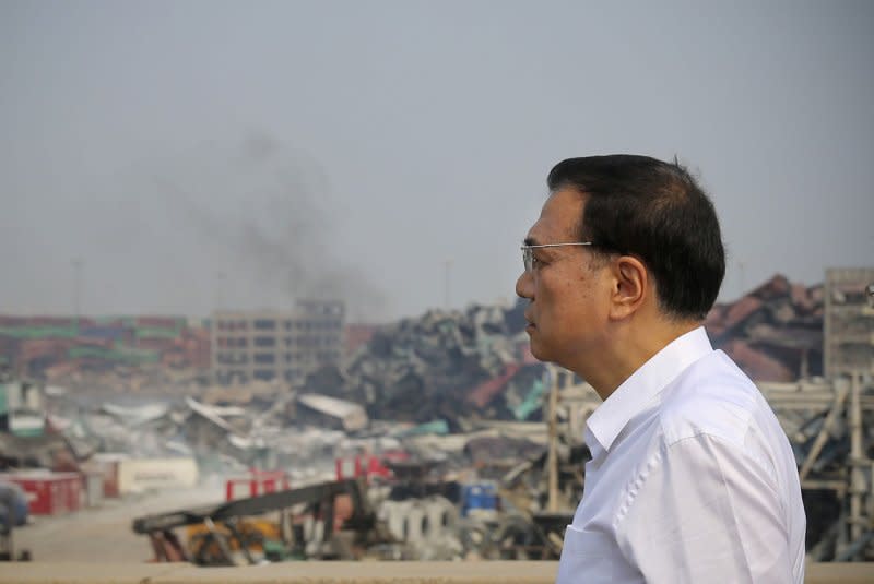 Chinese Premier Li Keqiang inspects the blast area and rescue operations from the roof of a building close to the massive fire and explosion zone caused by hazardous materials stored in a warehouse owned by Ruihai International Logistics in Tianjin on August 17, 2015. File Photo courtesy of Government Handout/UPI