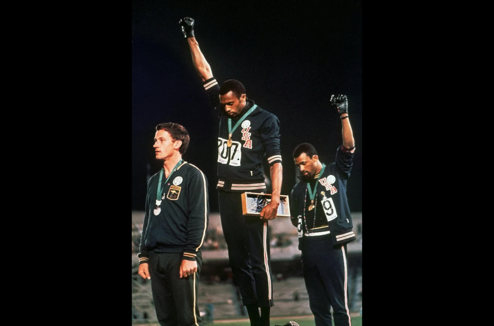 FILE - In this Oct. 16, 1968 file photo, U.S. athletes Tommie Smith, center, and John Carlos raise their gloved fists after Smith received the gold and Carlos the bronze for the 200 meter run at the Summer Olympic Games in Mexico City. Some athletes are criticizing the International Olympic Committee for prohibiting political protests on the medal podium. Olympic officials reminded athletes last week not to make political statements at the Tokyo Olympics. (AP Photo/File)