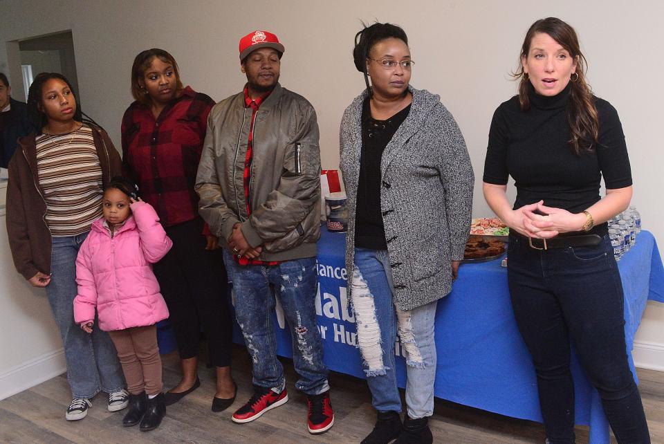 Niki McIIvain, right, executive director of the Alliance Area Habitat for Humanity, stands Sunday, Dec. 17, 2023, with Lawrence and Kelly Williams and their children during an event in which the Williamses received the keys to the home on Noble Street.