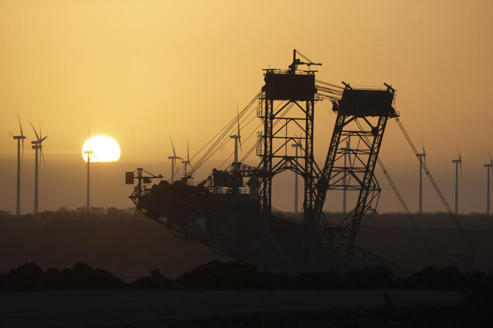 The sun rises behind a lignite excavator at the Garzweiler lignite coal mine near the village of Luetzerath, Erkelenz, Germany, Tuesday, Jan. 10, 2023. The village of Luetzerath has to be demolished to expand the Garzweiler lignite coal mine near the dutch border. (AP Photo/Michael Probst)