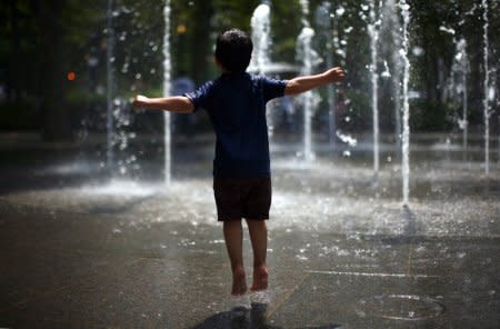 FILE PHOTO: A boy plays at a fountain in Battery Park in New York June 20, 2010. REUTERS/Eric Thayer