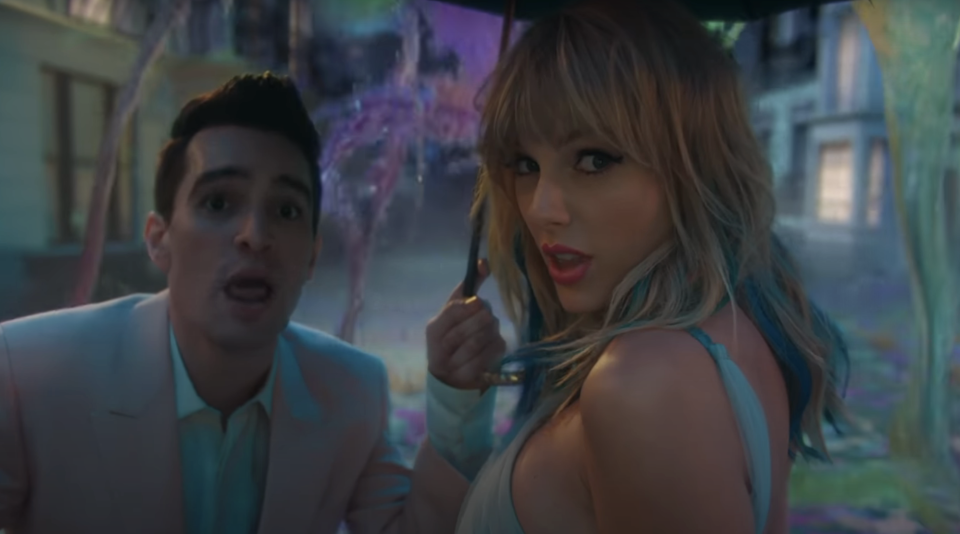 Brendan Urie and Taylor Swift under an umbrella as colorful goo splashes around them