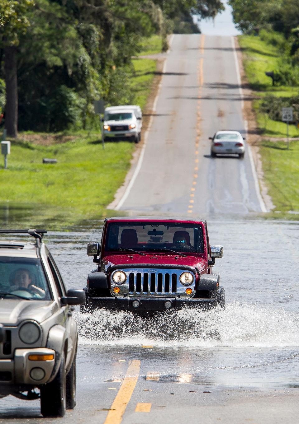 Motorists make their way through the flooded waters along Southeast 36th Avenue near Belleview in 2017 during the aftermath of Irma.