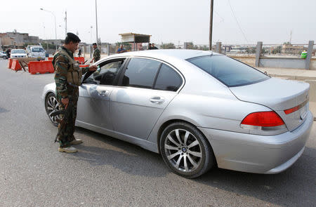 A policeman checks a driver's identification at a checkpoint in Kirkuk, Iraq, October 24, 2016 REUTERS/Ako Rasheed