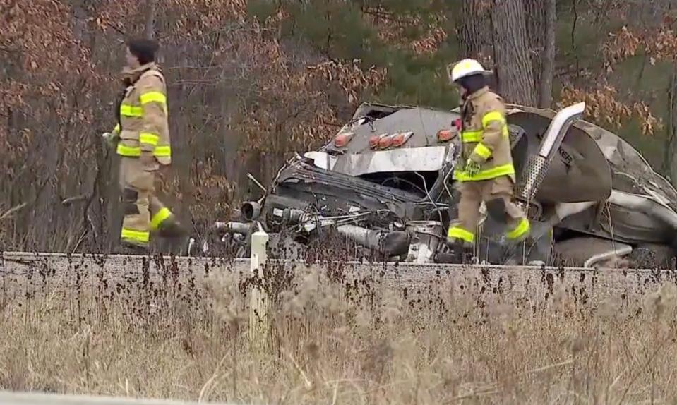 Firefighters examine the wreckage of a tanker truck at the scene of a crash near Dewhurst, between Neillsville and Black River Falls.