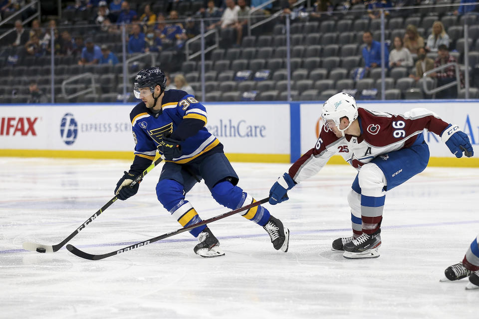 St. Louis Blues' Steven Santini (36) handles the puck while under pressure from Colorado Avalanche's Mikko Rantanen (96) during the second period in Game 3 of an NHL hockey Stanley Cup first-round playoff series Friday, May 21, 2021, in St. Louis. (AP Photo/Scott Kane)