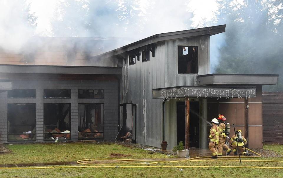 Assistant Chief Brent McBride, Lieutenant Adam Graham and Firefighter Jake Zvirzdys (left-right) from the South Bay Fire Dept. watch for hot spots Tuesday after an early morning fire destroyed a home in the 6900 block of Marvin Road Northeast in what is believed to have been arson.