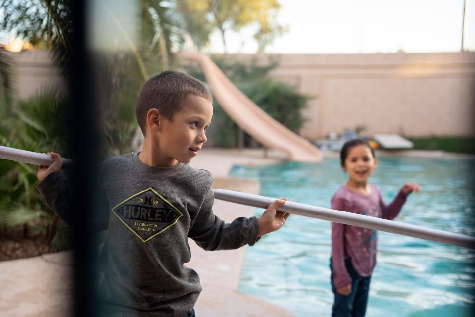 Adriel and Alvira Arvizo play in the backyard of their temporary home in Avondale, Arizona, on Nov. 18, 2022.