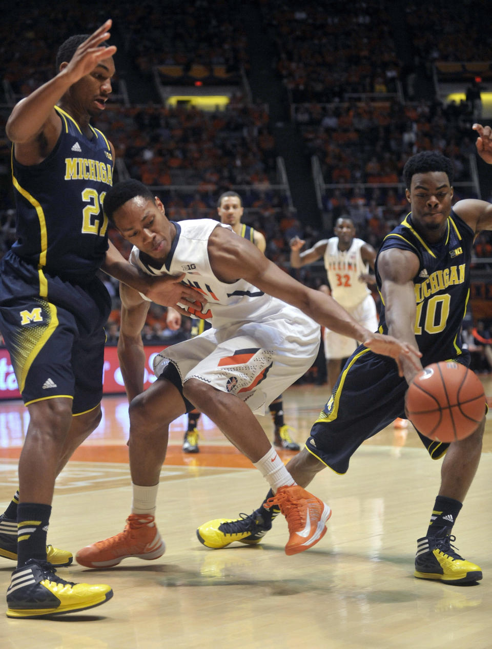 Illinois guard Joseph Bertrand (2) loses the ball between Michigan guards Zak Irvin (21) and Derrick Walton Jr. (10) during the first half of an NCAA college basketball game Tuesday, March 4, 2014, in Champaign, Ill. (AP Photo/Rick Danzl)