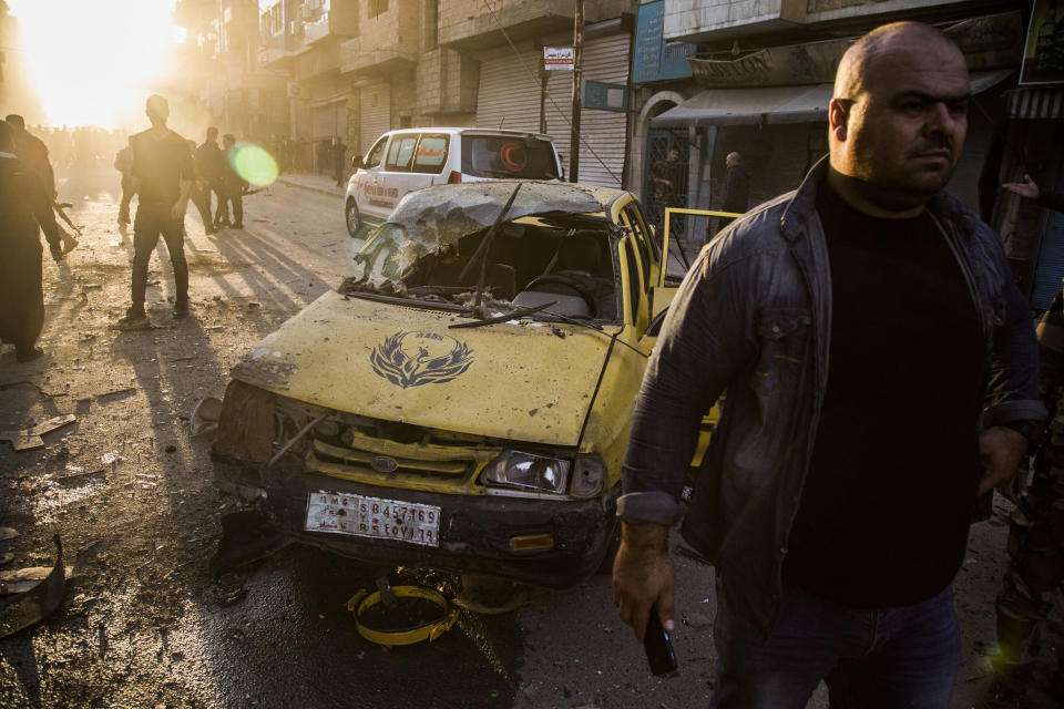 People check the aftermath of a car bomb blast in the city of Qamishli, northern Syria, Monday, Nov. 11, 2019. Three car bombs went off Monday in then city killing several and wounding tens of people. (AP Photo/Baderkhan Ahmad)