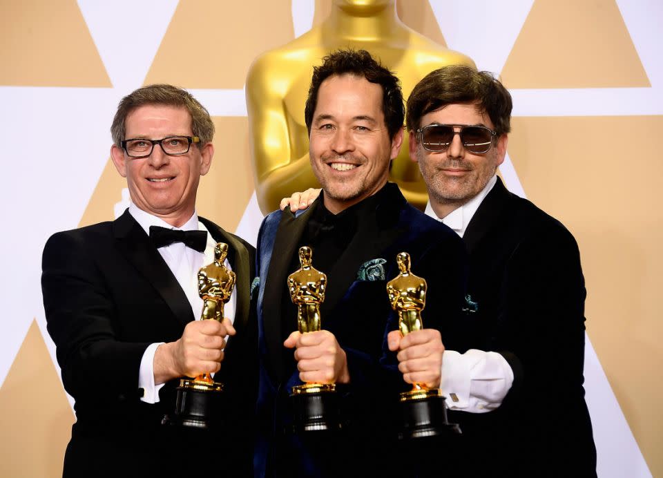 Set decorator Jeffrey A. Melvin, production designer Paul Denham Austerberry, and set decorator Shane Vieau, winners of the Best Production Design award for 'The Shape of Water,' pose in the press room with their prestigious prize. Source: Getty