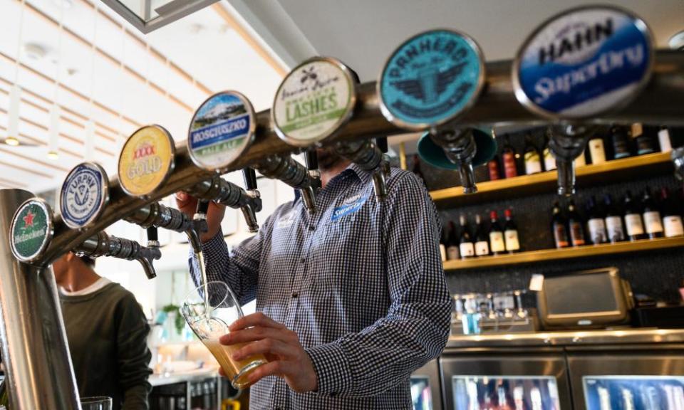 A barman pours a beer at a bar in Sydney, Australia