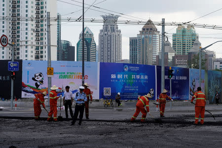 Workers pave a road ahead of the China International Import Expo in Shanghai, China September 27, 2018. REUTERS/Aly Song