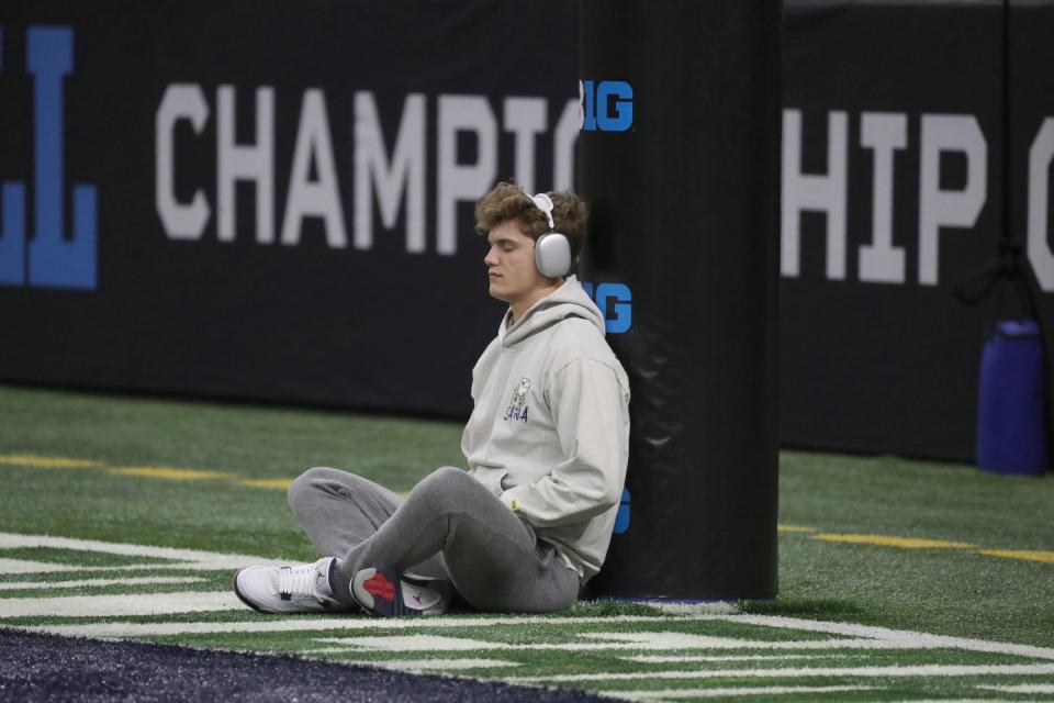 Michigan Wolverines quarterback J.J. McCarthy (9) meditates before the Big Ten championship game against the Purdue Boilermakers at Lucas Oil Stadium in Indianapolis on Saturday, Dec. 3, 2022.