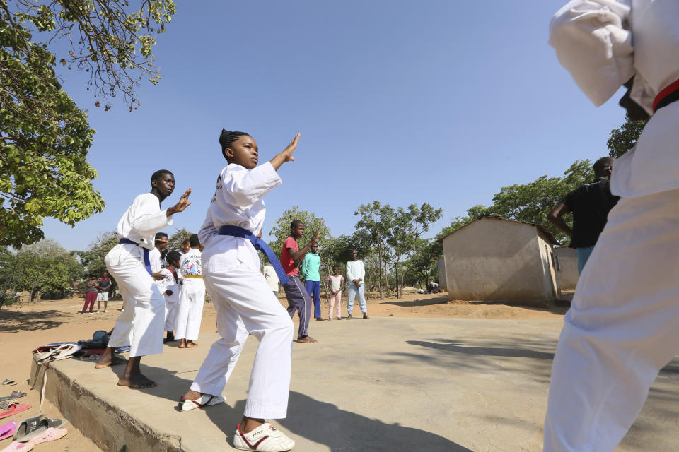 Natsiraishe Maritsa, center, goes through taekwondo kicking drills during a practice session in the Epworth settlement about 15 km southeast of the capital Harare, Saturday Nov. 7, 2020. In Zimbabwe, where girls as young as 10 are forced to marry due to poverty or traditional and religious practices, a teenage martial arts fan 17-year old Natsiraishe Maritsa is using the sport to give girls in an impoverished community a fighting chance at life. (AP Photo/Tsvangirayi Mukwazhi)