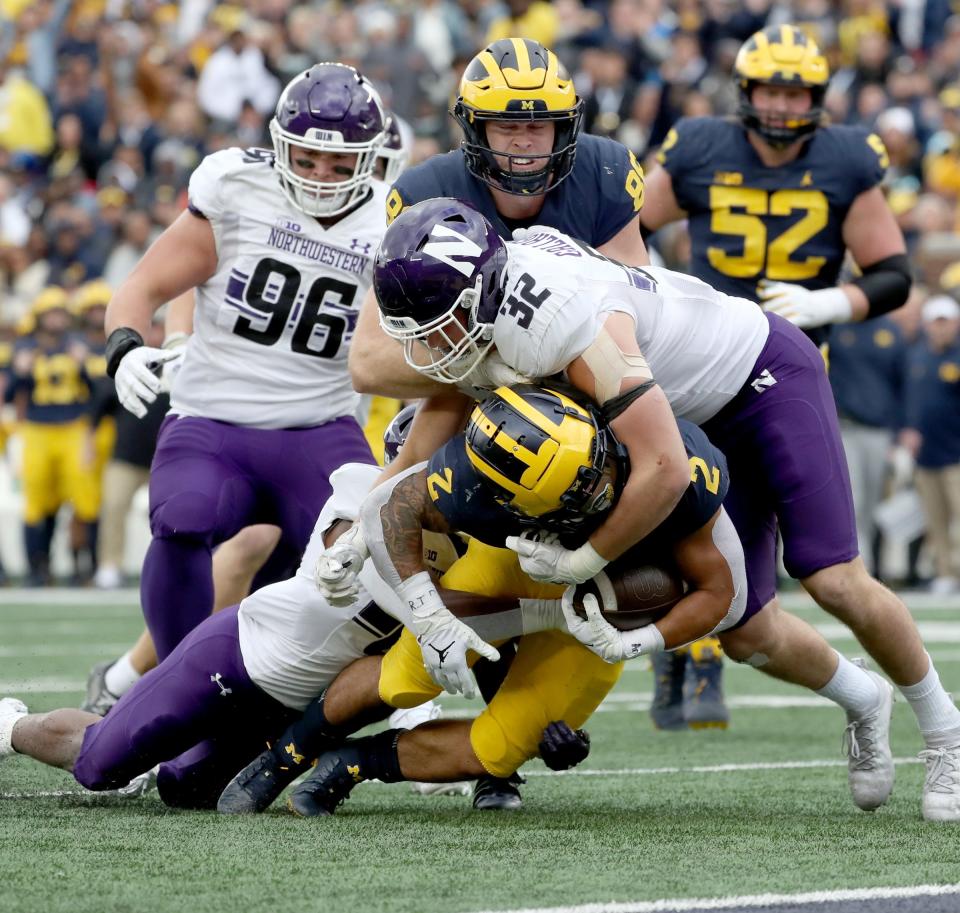 Michigan running back Blake Corum is tackled by Northwestern linebacker Bryce Gallagher during the first half on Saturday, Oct.23, 2021, at Michigan Stadium.