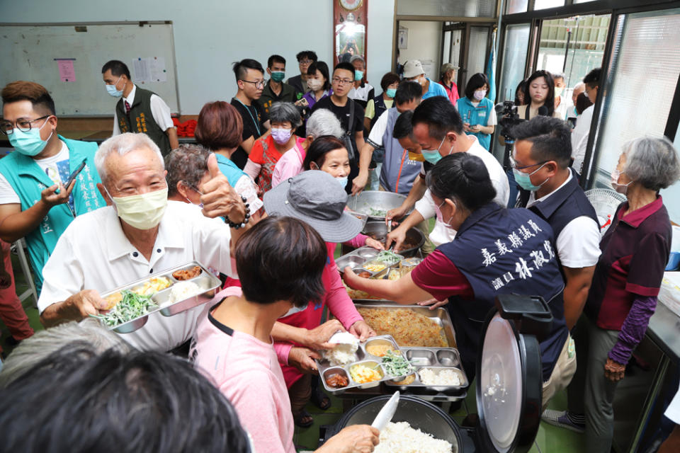 縣長翁章梁為長輩添飯打菜，長輩開心大讚。（記者張翔翻攝）