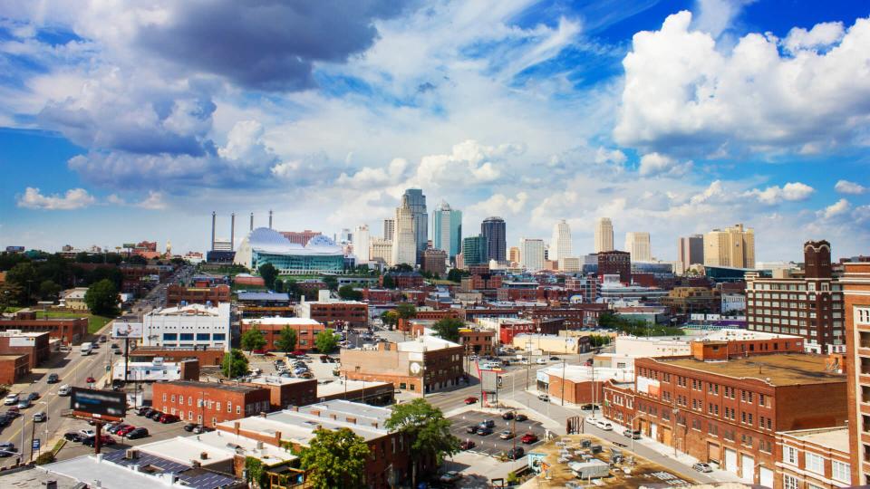 Downtown Kansas City, Missouri at daytime under a big blue sky and striking clouds.