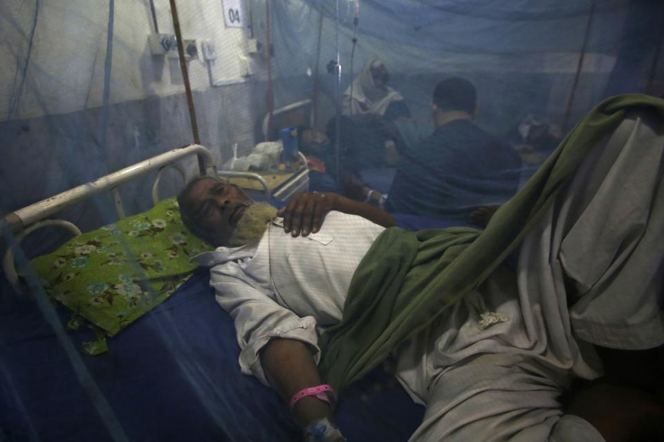 FILE - A man suffering from dengue fever, a mosquito-borne disease, is treated at a hospital, in Peshawar, Pakistan, Sept. 16, 2022. The flooding in Pakistan killed at least 1,700 people, destroyed millions of homes, wiped out swathes of farmland, and caused billions of dollars in economic losses. (AP Photo/Muhammad Sajjad, File)