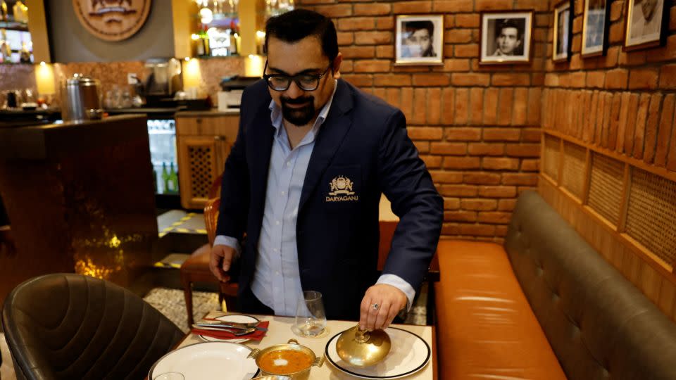 Amit Bagga, CEO of Daryaganj restaurant, shows a freshly prepared butter chicken dish and the lentil dish Dal Makhani inside a Daryaganj restaurant at a mall in Noida, India, January 23, 2024. - Sahiba Chawdhary/Reuters