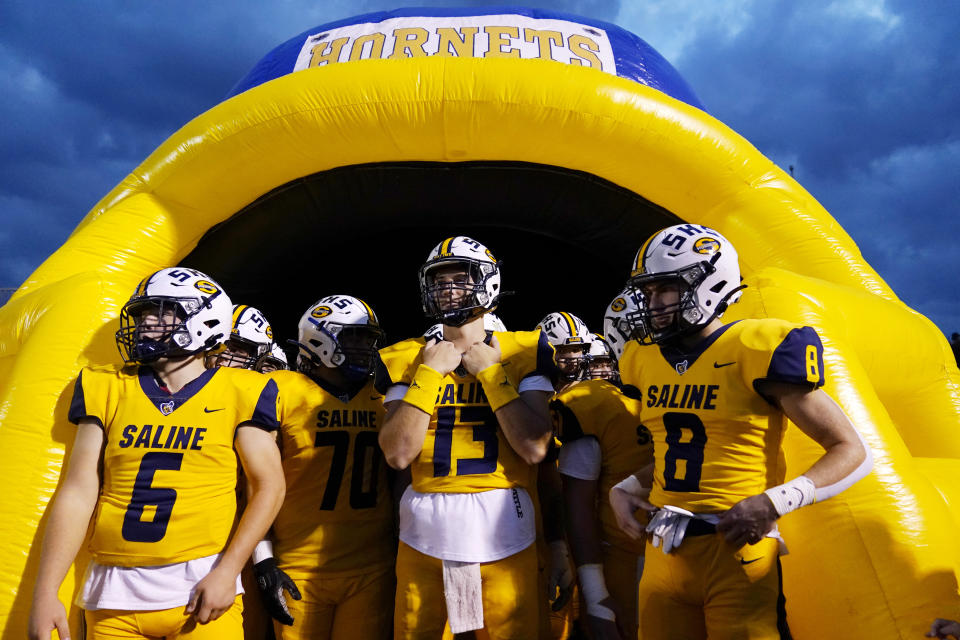 Saline High School quarterback CJ Carr (13) looks on before a football game Friday, Oct. 27, 2023, in Saline, Mich. Carr will be among the hundreds of football players to sign a national letter of intent this week, sealing his commitment to join Notre Dame, but no one has a story quite the same. (AP Photo/Carlos Osorio)