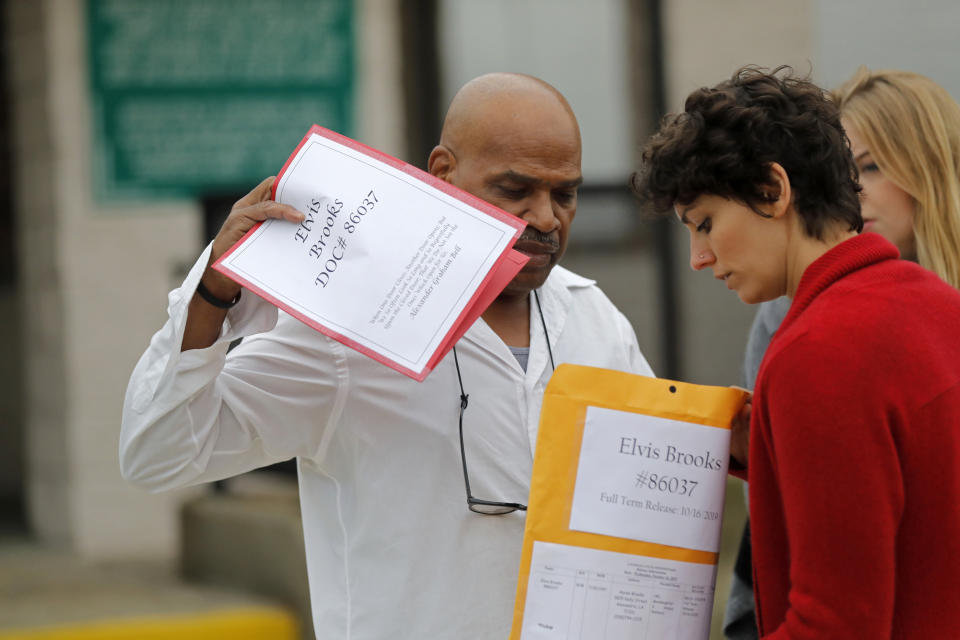 Elvis Brooks goes through his paperwork with members of the Innocence Project New Orleans after walking out of the Louisiana State Penitentiary at Angola in Angola, La., Wednesday, Oct. 16, 2019. Brooks, who has spent two-thirds of his life in prison for a killing he always denied committing, pleaded guilty to manslaughter and was released. Since his arrest in 1977, he has maintained that he's innocent. Innocence Project New Orleans attorneys say evidence that would have cleared him was withheld at trial. Prosecutors offered the plea agreement Tuesday which was accepted. (AP Photo/Gerald Herbert)