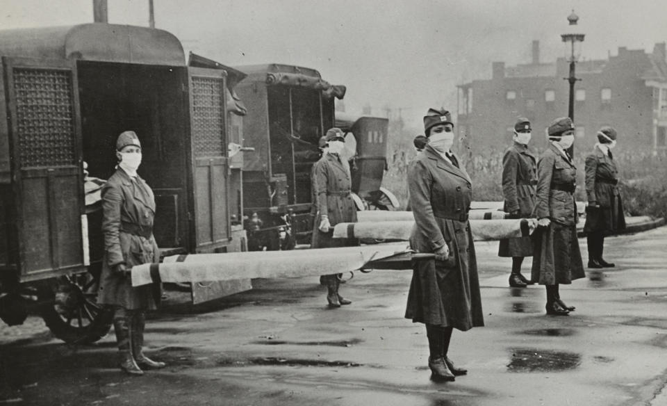 Red Cross Motor Corps. members holding stretchers behind ambulances in St. Louis (Universal History Archive / Universal Images Group via Getty Images)