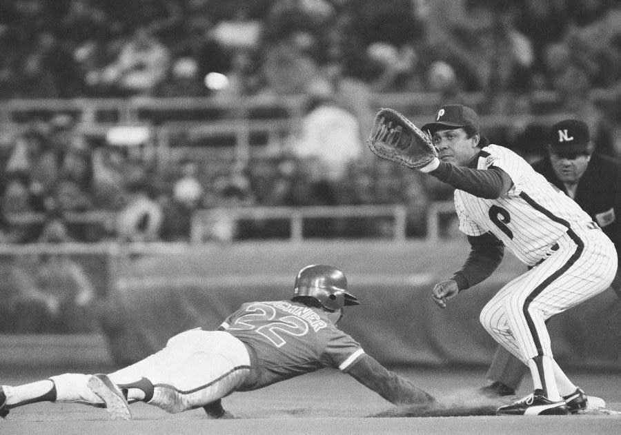 Chicago Cubs first baseman Bill Buckner dives safely back to first base beating the throw to Philadelphia Phillies first baseman Tony Perez during the first inning of National League play at Veterans stadium in Philadelphia, Monday, April 18, 1983. First base umpire Bob Engel appears at right. (AP Photo/Peter Morgan)