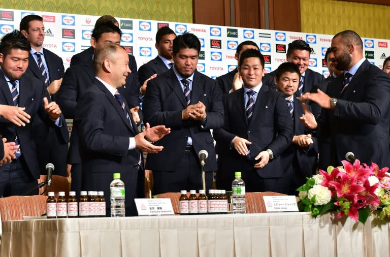 Japan's rugby union national team head coach Eddie Jones (C-L) and team members, pictured a press conference in Tokyo on October 13, 2015, following their return from the Rugby World Cup