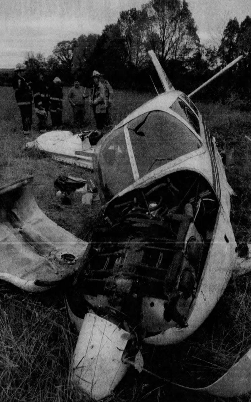 Firefighters discuss the plane that crashed on Monday, Oct. 12, 1998, at a field near Sky Manor Airport in Alexandria Township. Authorities believed the pilot might have been unfamiliar with the airport.