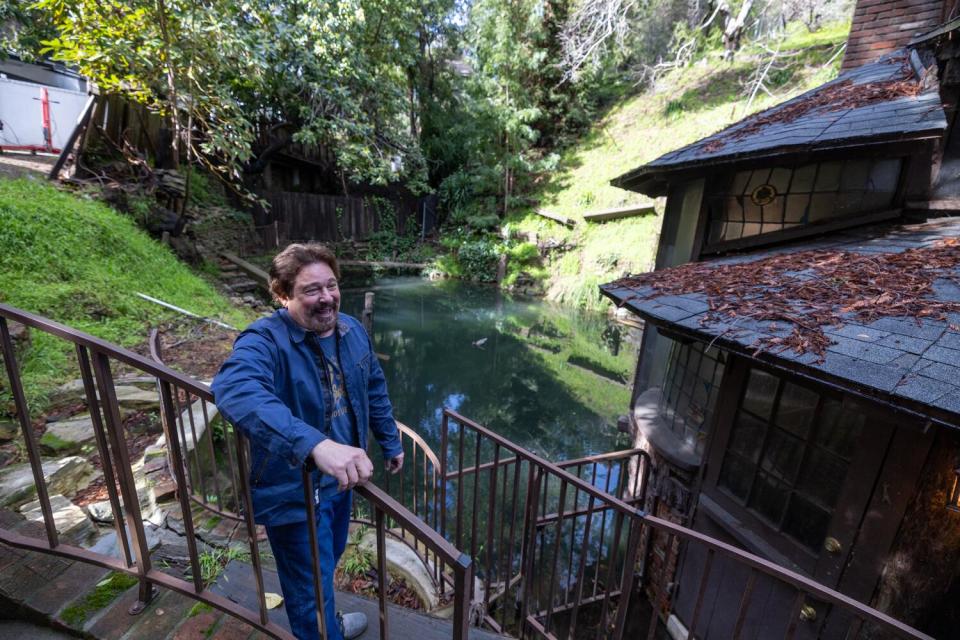 Tony Tucci stands on a stairway beside a spring.