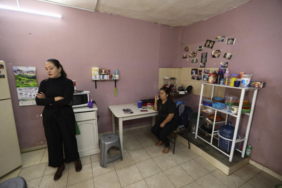 Rosa Alba Santoyo, right, speaks on the phone the day after she lost her three adult children in an attack on the drug rehabilitation center where they were being treated, as neighbors visit her home to give their condolences in Irapuato, Mexico, Thursday, July 2, 2020. Gunmen burst into the drug rehabilitation center and opened fire Wednesday, killing 24 people and wounding seven, authorities said. (AP Photo/Eduardo Verdugo)