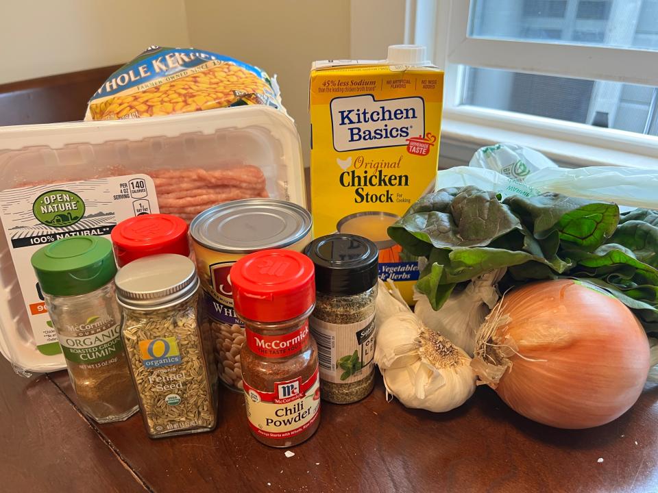 Onions, garlic, ground chicken, broth, and spices on table