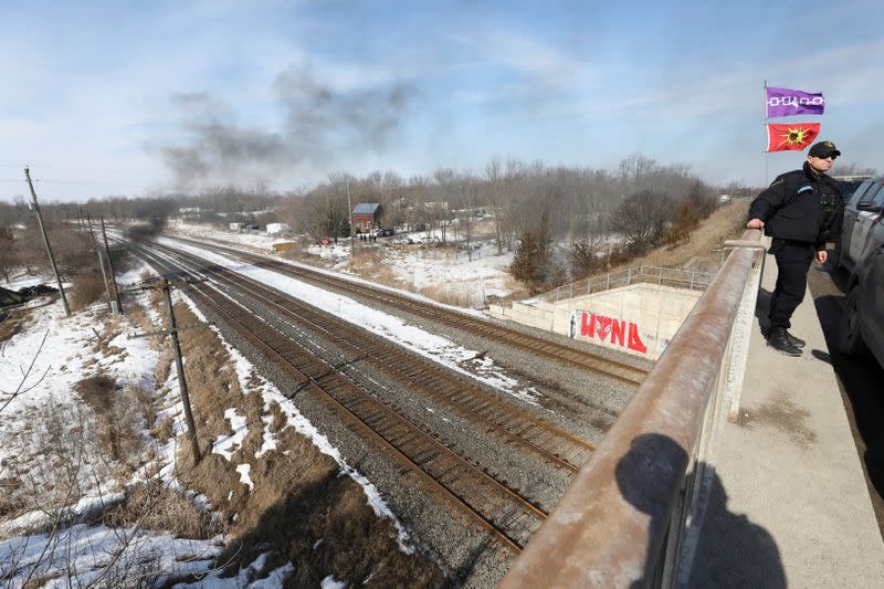 Police on the road bridge over the train tracks stand guard near to a second smaller encampment during a raid to the Tyendinaga Mohawk Territory main camp in Tyendinaga