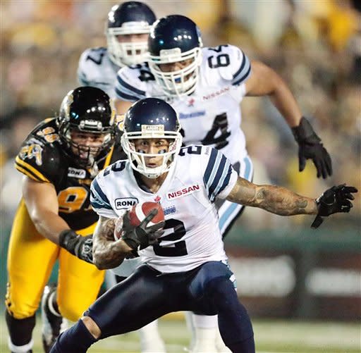 Toronto Argonauts' Chad Owens avoids a tackle from Hamilton Tiger-Cats' Eddie Steele, left, during their 36-27 loss to the Ti-Cats in their Canadian Football League game at Ivor Wynne Stadium in Hamilton, Ontario, Saturday, July 14, 2012. (AP Photo/The Canadian Press, Geoff Robins)