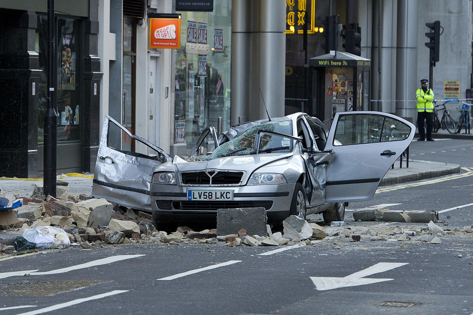 A smashed up car is seen in Kingsway opposite Holborn Tube station in central London, after a woman was killed when large chunks of masonry fell onto a Skoda Octavia vehicle she was in, London, Saturday, Feb. 15, 2014. The taxi driver was killed late Friday in central London opposite Holborn subway station during a heavy windstorm when her car was crushed by falling masonry from a building that partially collapsed, police said. She was identified as Julie Sillitoe, a 49-year-old with three sons. (AP Photo/PA, Laura Lean) UNITED KINGDOM OUT