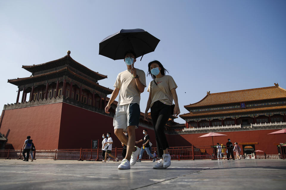 Visitors wearing face masks to help protect against the coronavirus visit Forbidden City in Beijing, Thursday, Aug. 13, 2020. New local cases in China fell into the single digits, while Hong Kong saw another rise in hospitalizations and deaths. (AP Photo/Andy Wong)